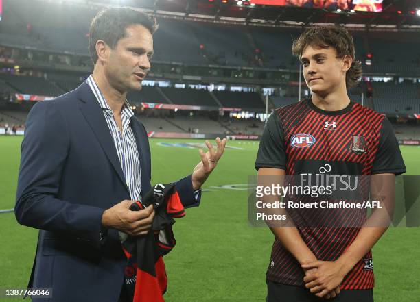 Former Essendon player Gavin Wanganeen presents his son, Tex Wanganeen of the Bombers with his jumper prior to the round two AFL match between the...