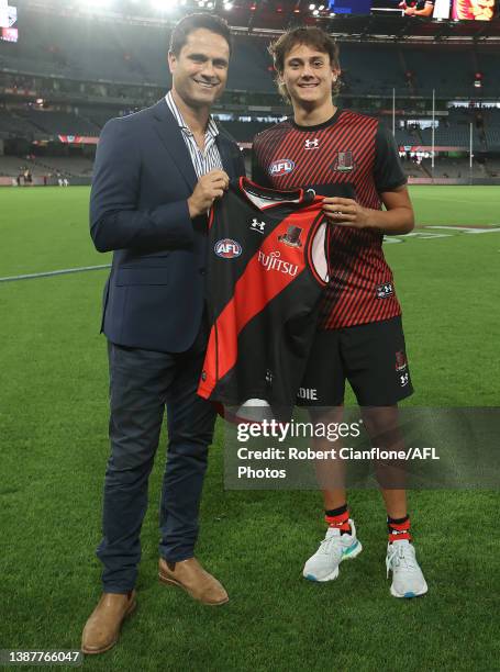 Former Essendon player Gavin Wanganeen presents his son, Tex Wanganeen of the Bombers with his jumper prior to the round two AFL match between the...