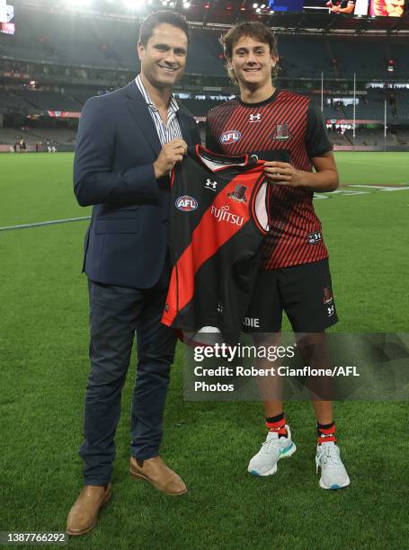 Former Essendon player Gavin Wanganeen presents his son, Tex Wanganeen of the Bombers with his jumper prior to the round two AFL match between the...