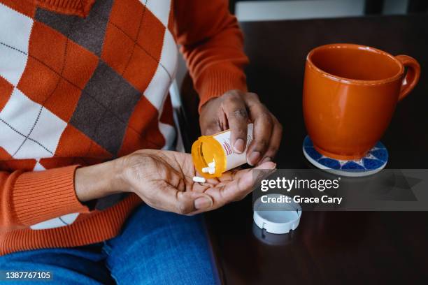 woman takes prescription medication - pijnstiller stockfoto's en -beelden