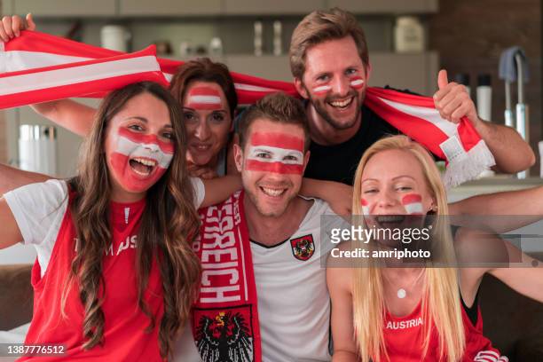 österreichische fans jubeln zu hause für ihr team - austria flag stock-fotos und bilder