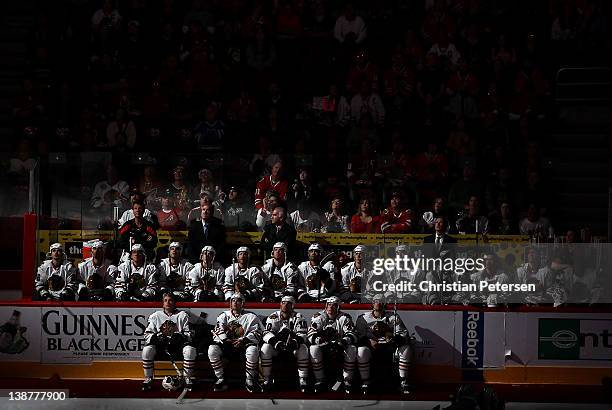 The Chicago Blackhawks sit on the bench and watch the pregame ceremony before the NHL game against the Phoenix Coyotes at Jobing.com Arena on...