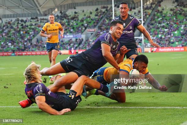 Waqa Blake of the Eels scores a try as he is tackled by Reimis Smith and Ryan Papenhuyzen of the Storm during the round three NRL match between the...