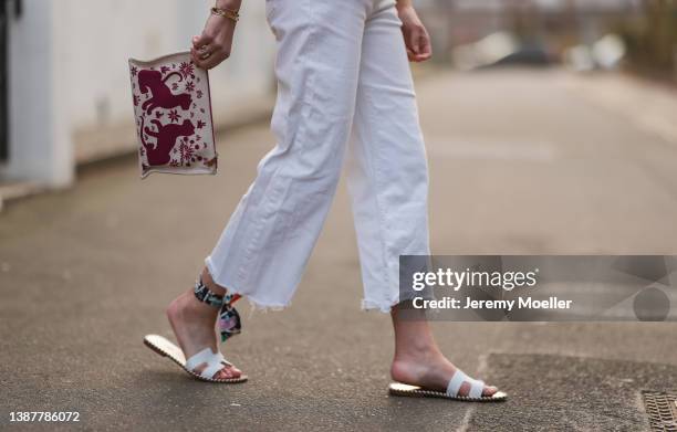 Yasmin von Schlieffen-Nannen wearing Mother white denim jeans, Hermes linen mini clutch, Hermes white leather sandals and ancle scarf on March 24,...