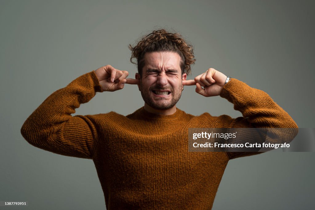 Man covering his ears
