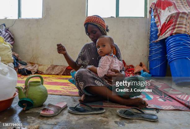 Year old Ticey Yassey and her 2 year old son currently share a room with 31 other IDP's from Abala at the Afdera High School on March 25, 2022 in...