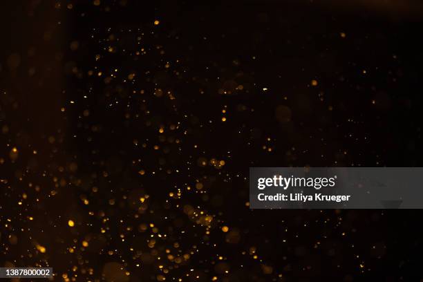 golden dust on black background. - defokussiert stock-fotos und bilder