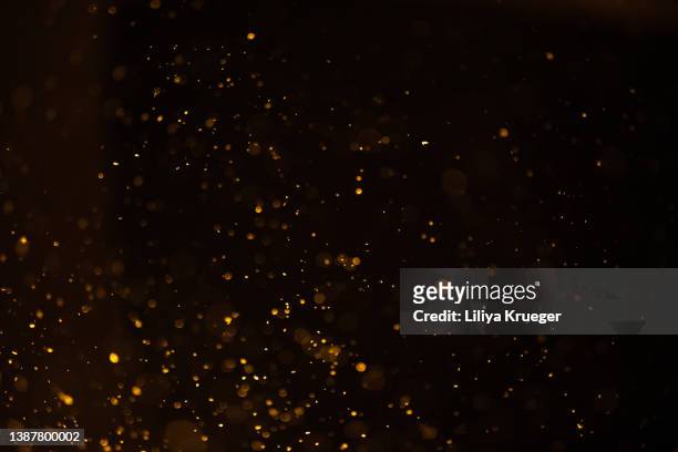 golden dust on black background. - murky water stockfoto's en -beelden