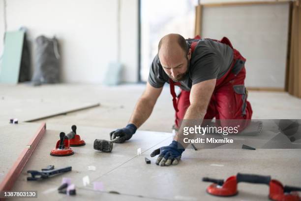construction builder adjusting tiles - flooring contractor stock pictures, royalty-free photos & images