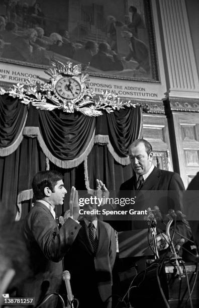 American politician MIchael Dukakis takes an oath as he sworn in as the 65th Governor of Massachusetts by State Senate President Kevin Harrington,...