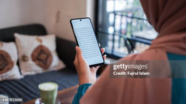 reading quran on smartphone apps - hijab woman from behind stock pictures, royalty-free photos & images