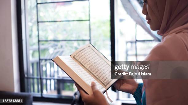 asian woman reading the quran - koran stock pictures, royalty-free photos & images
