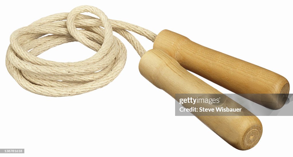 A coiled up classic jump rope with wood handles