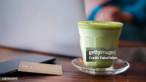 green matcha tea and credit card and smartphone on the table at cafe - healthy lifestyle no people stock pictures, royalty-free photos & images