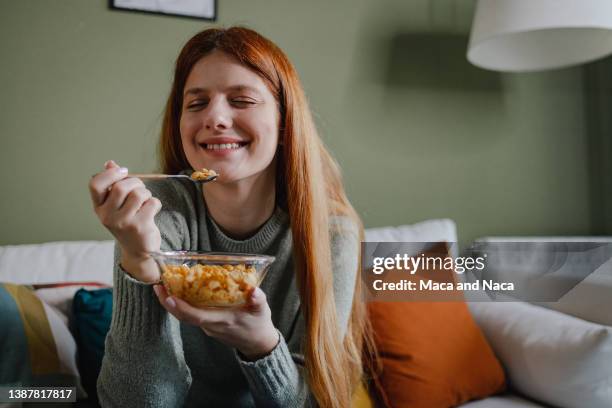 joven feliz, sonriendo mientras desayuna - oats food fotografías e imágenes de stock