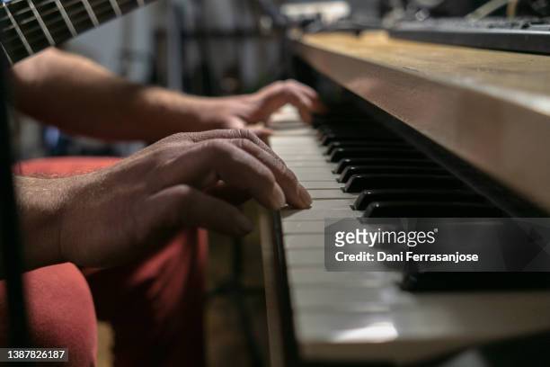 close-up shot of hands playing an electric piano in a recording studio - electric piano fotografías e imágenes de stock