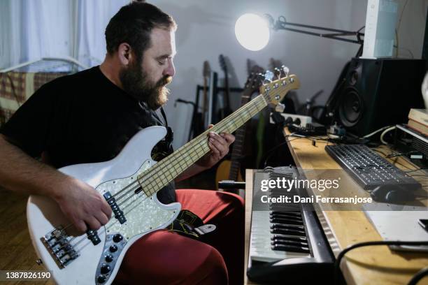 musician songwriter recording a song with an electric bass guitar in his recording studio - bass player bildbanksfoton och bilder