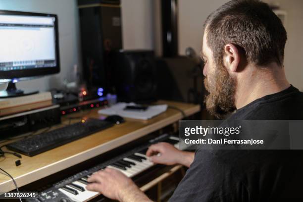 musician composer recording a piece by piano in his recording studio in the evening - electric piano fotografías e imágenes de stock
