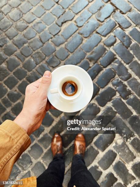 man drinking espresso on the street in rome, personal perspective directly above view - espresso mann stock-fotos und bilder