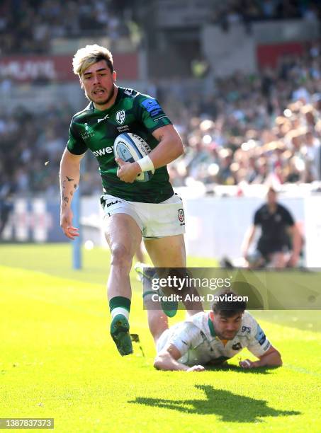 Ollie Hassell-Collins of London Irish breaks away from George Furbank of Northampton Saints to score his sides first try during the Gallagher...