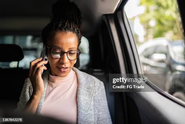 mature woman talking on the mobile phone in the car - african car stock pictures, royalty-free photos & images