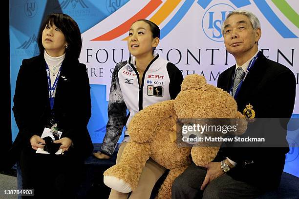 Reiko Kobayashi, Mao Asada of Japan and her coach, Nobuo Sato, watch her scores after the Ladies Free Skate during the ISU Four Continents Figure...