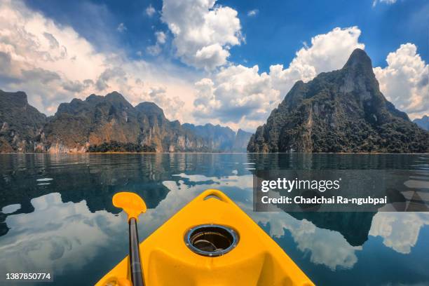 kayak among mountains view, clear sky and clear water in the cheow lan dam (ratchaprapa dam), khao sok national park, surat thani, thailand - khao lak stock pictures, royalty-free photos & images