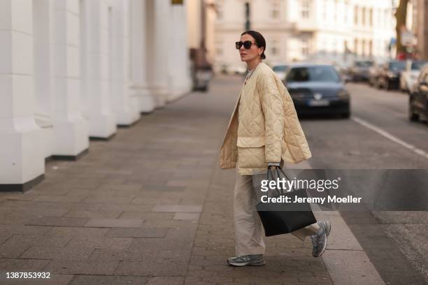 Elise Seitz is seen wearing New Balance grey sneaker, COS beige wide linen pants, Soho Studios grey oversized sweater, Nina Kastens gold bold chain,...