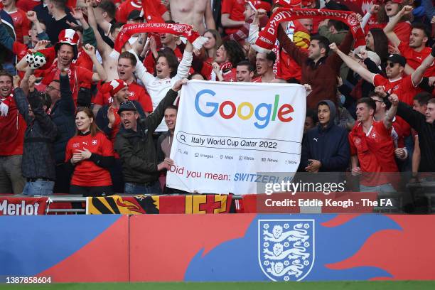 Switzerland fans hold a banner aimed at Italy after they failed to qualify for the World Cup prior to the International Friendly match between...