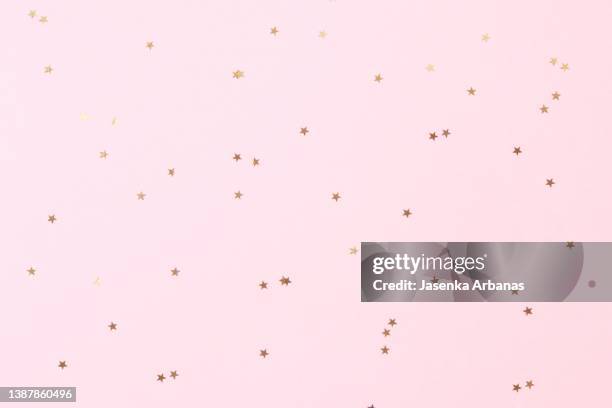 golden confetti on the pink background - new pink background stock pictures, royalty-free photos & images
