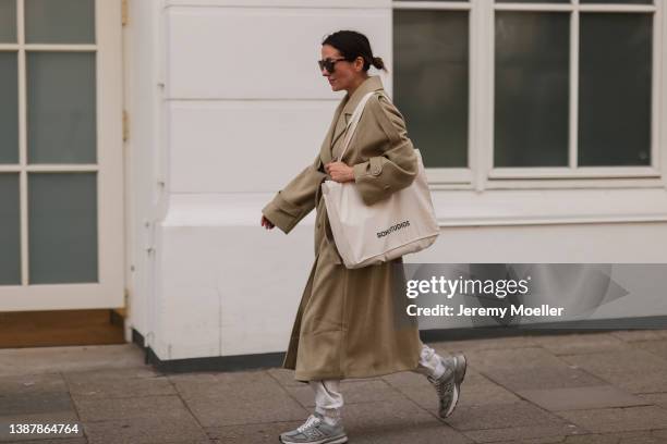 Elise Seitz is seen wearing a Nakd pastell green maxi coat, Hey Soho grey matching jogging suit with matching sweater and pants, New Balance grey...