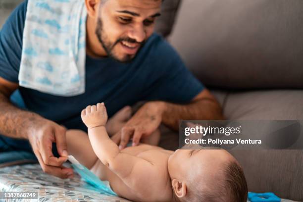 father changing baby's diaper - reusable diaper stock pictures, royalty-free photos & images