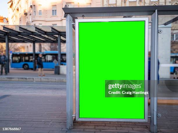 large professional green screen chroma key marketing advertisement billboard in european city centre train, tram and bus station environment targeting adverts at transport customers, shoppers, commuters on the way to work and tourists on vacation. - billboard bus stockfoto's en -beelden