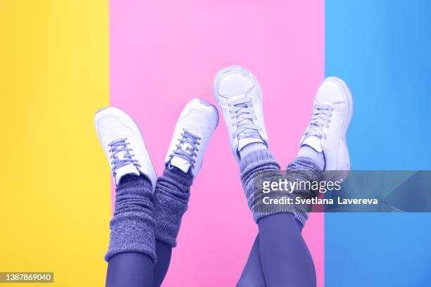 woman legs in stylish sneakers on colored background. close up photo. space for text - colorful shoes stock pictures, royalty-free photos & images