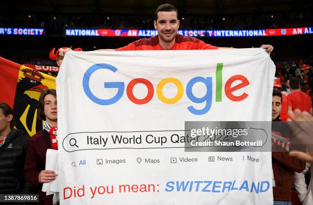 Switzerland fan holds a banner aimed at Italy after they failed to qualify for the World Cup during the International Friendly match between England...