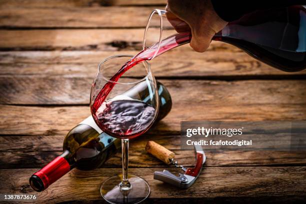 pouring wine from decanter into a wineglass. - hand pouring stock pictures, royalty-free photos & images
