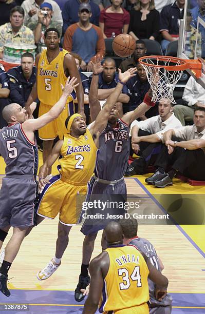 Derek Fisher of the Los Angeles Lakers goes to the basket in between Jason Kidd and Kenyon Martin of the New Jersey Nets during Game two of the 2002...