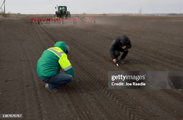 Holovanych Andrii, and Kaluzhniak Andrii, both of whom are agronomist with the Zahidnyi Bug Farm, help plant sugar beet seeds on March 26, 2022 in...