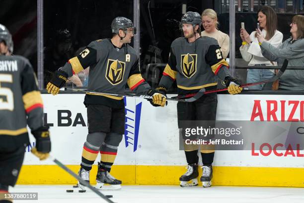 Alec Martinez and Shea Theodore of the Vegas Golden Knights interact during warmups prior to facing the Chicago Blackhawks at T-Mobile Arena on March...