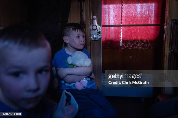 An orphan boy hugs a soft toy as he waits on a train after fleeing the town of Polohy which has come under Russian control before evacuating on a...