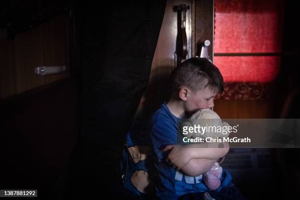 An orphan boy hugs a soft toy as he waits on a train after fleeing the town of Polohy which has come under Russian control before evacuating on a...