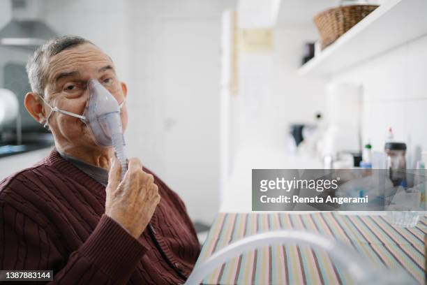 senior man doing inhalation with nurse at home - respiratory disease stock pictures, royalty-free photos & images