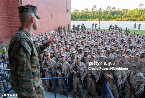 Marine Corps officer, left, gives a motivational speech after Marine recruits received their Eagle, Globe and Anchor medals during the traditional...
