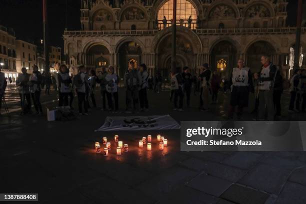 Members stand in St. Mark's Square during Earth Hour, WWF's global initiative, major squares around the world will remain dark for one hour to raise...