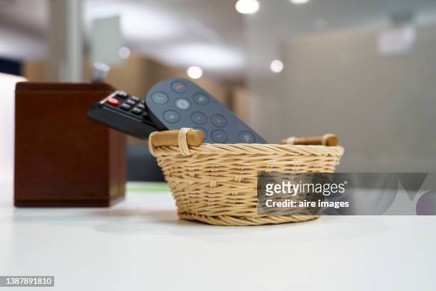 remote control organized inside a basket on a table unfocused background indoor home - convenience basket stock pictures, royalty-free photos & images