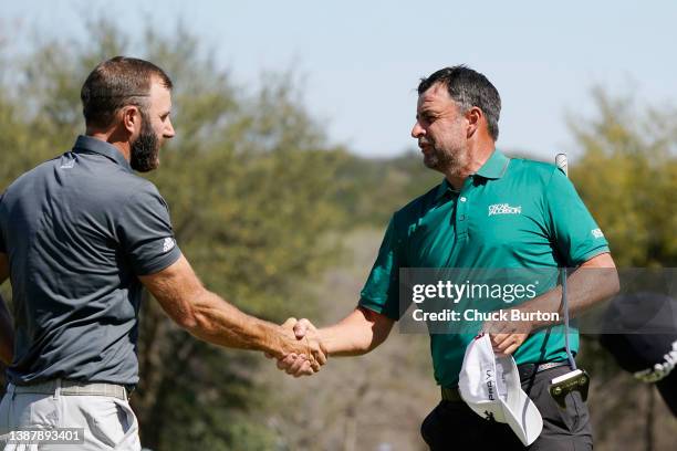 Dustin Johnson of the United States shakes hands with Richard Bland of England after defeating him 3&2 on the 16th green in their Round of 16 match...