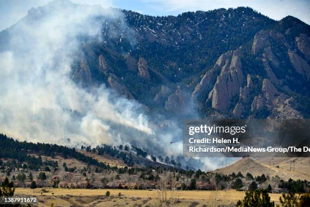 Single engine air tanker drops water on the NCAR fire as it burns in the foothills south of the National Center for Atmospheric Research on March 26,...