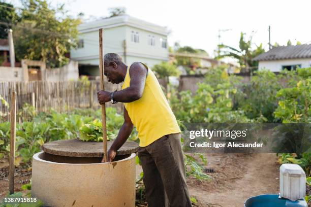 man collecting water from a well in the vegetable garden - 1 earth productions stock pictures, royalty-free photos & images