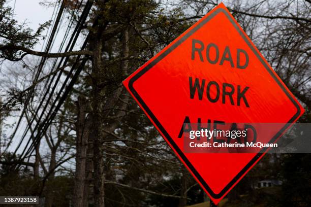bright orange road work ahead street sign - señal-de-obras-en-la-vía fotografías e imágenes de stock