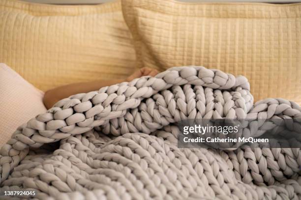 unrecognizable female under weighted blanket in bed - thick stock pictures, royalty-free photos & images